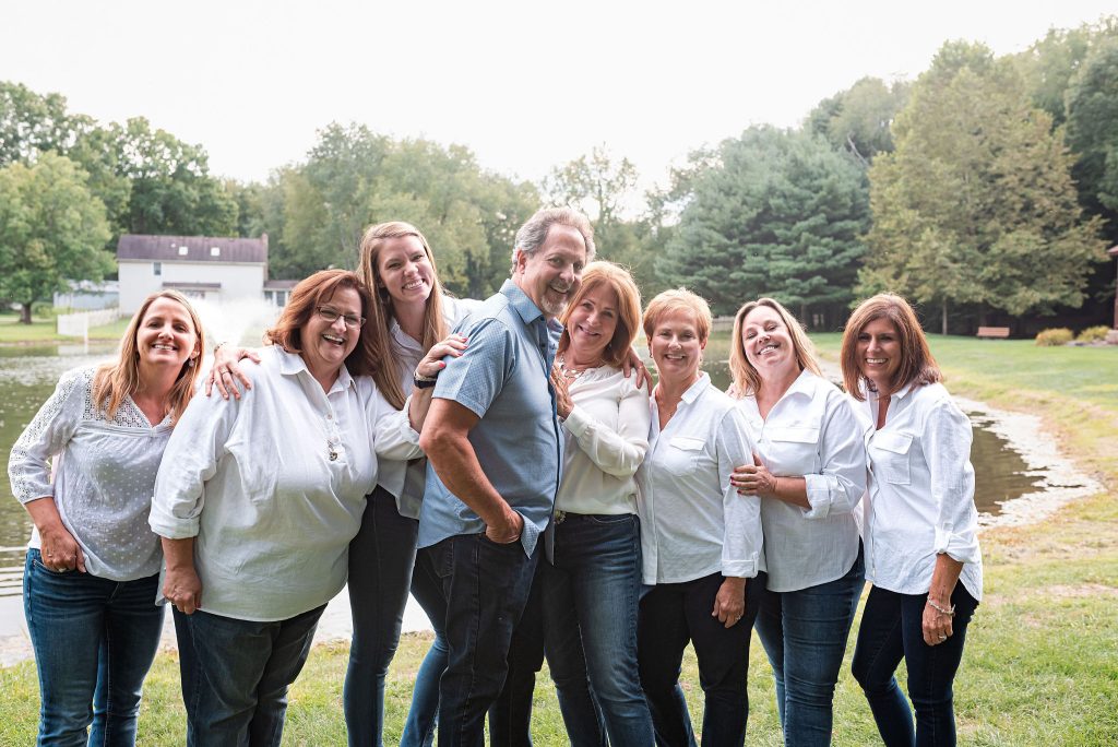 Peak Dental Arts team outdoors for group team photo in front of pond with trees in the background
