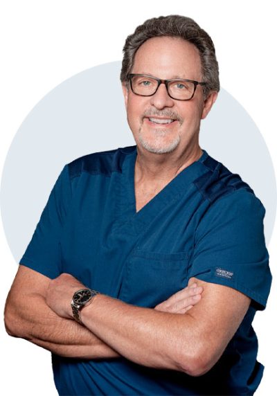 Silhouette image of Dr. Lanik, the best family dentist in Uniontown, OH with light gray background. Dr. Lanik is wearing dark blue scrubs and black wristwatch with his arms crossed.