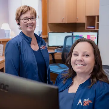 Two Peak Dental Arts team members at the front desk